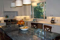 A kitchen with an island finished with a green granite countertop